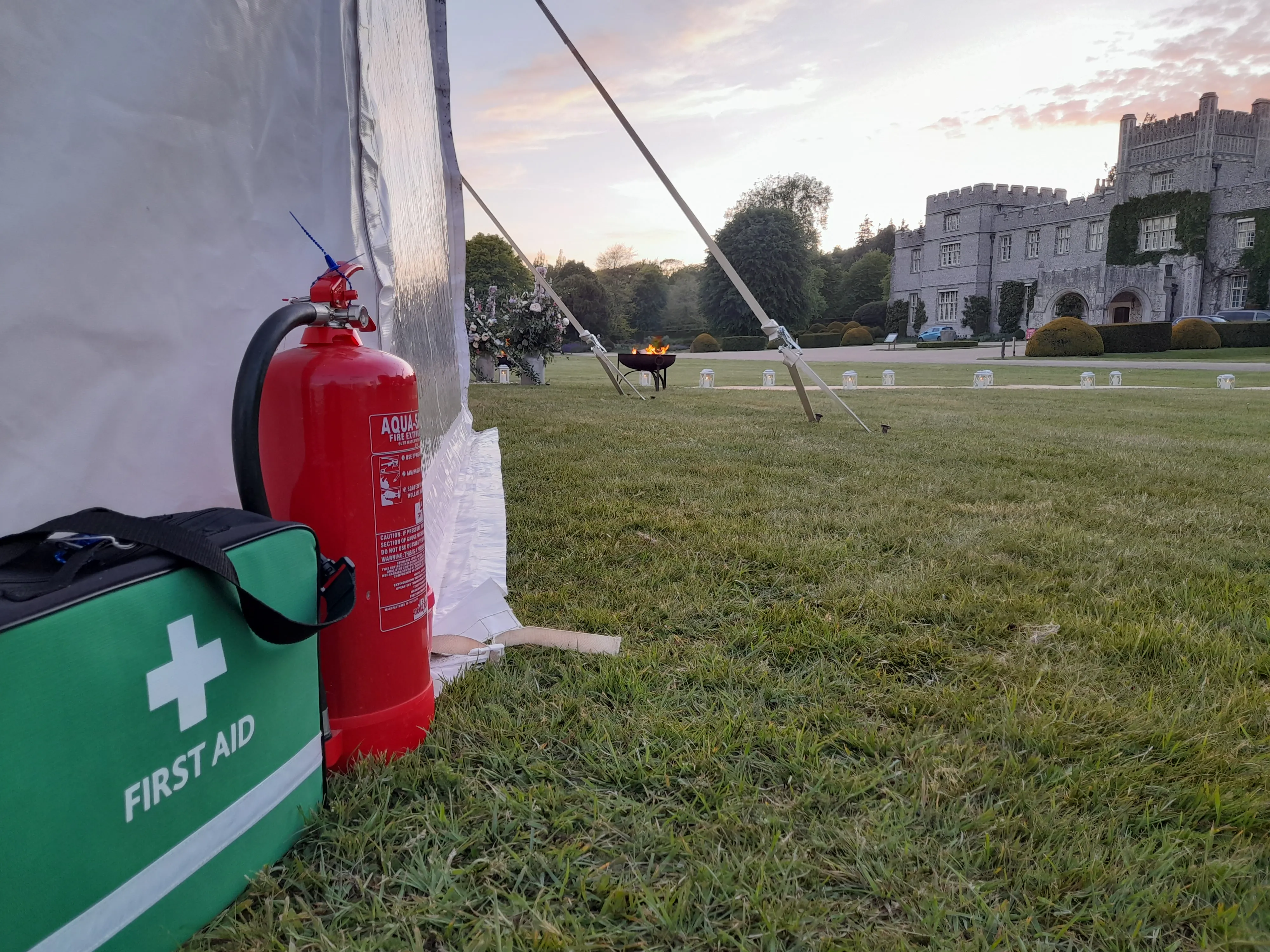 A red fire extinguisher next to a first aid kit.